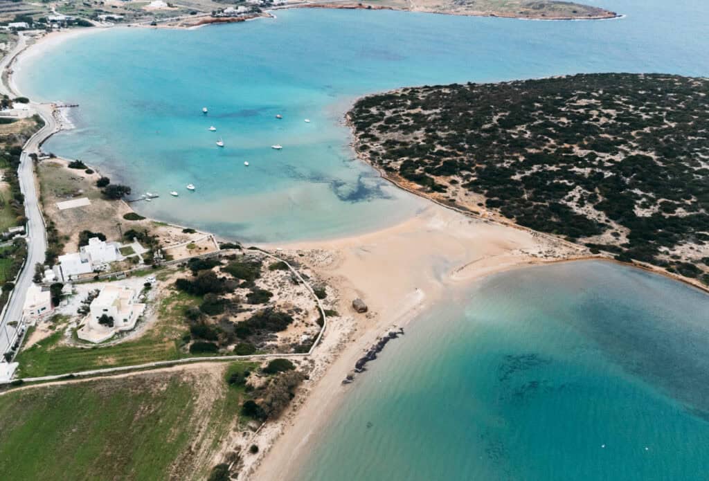 A drone photo that we took of Agios Stefanos Beach leading out the a peninsula. You can see the coastline continue into Siparos Beach and a couple of buildings along the shore.