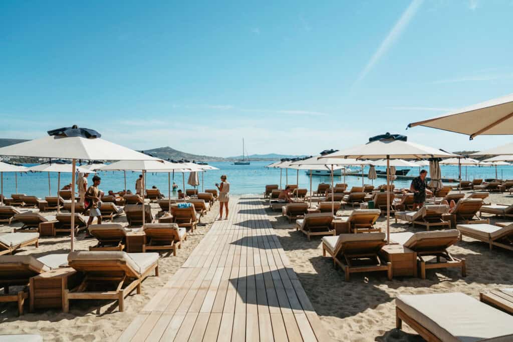 Boardwalk leading to rows of sunbeds and umbrellas at Marcello Beach Paros