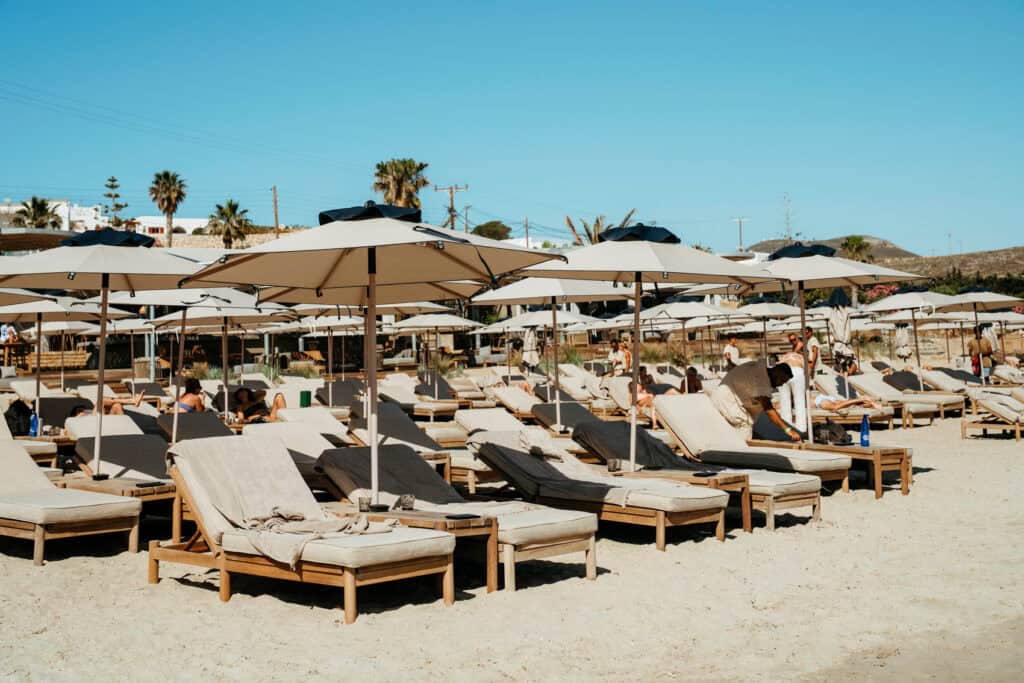Rows of sunbeds and umbrellas lined up on the golden sand at Marcello Beach Paros