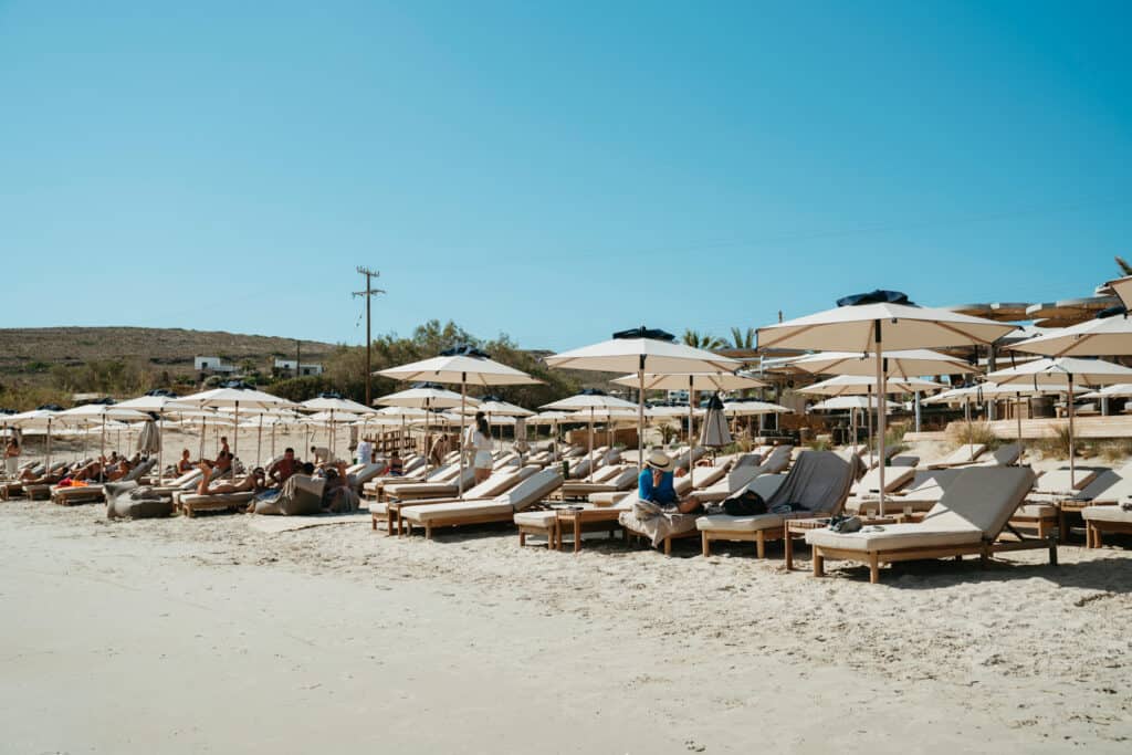 Rows of sunbeds and umbrellas lining the golden sand at Marcello Beach Paros