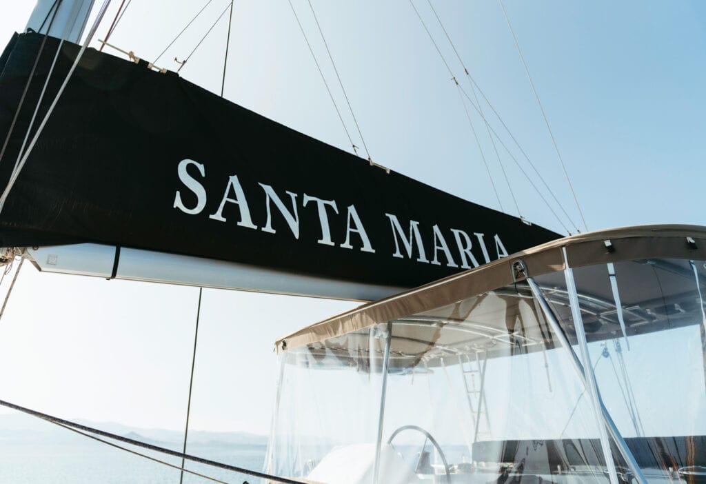 Close-up of the Santa Maria catamaran, a popular choice among the best boat tours in Naxos, with clear skies and the Aegean Sea in the background.