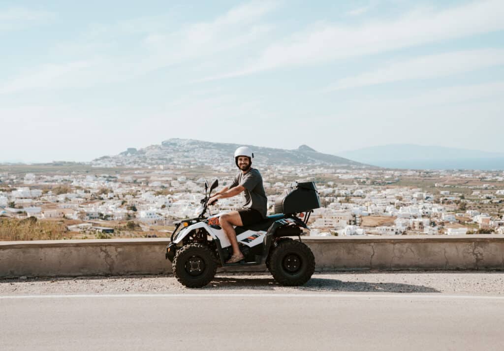 Caleb on an ATV rental in Paros with a beautiful view in the background.
